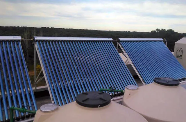 Colectores solares de tubos de vacío sobre una terraza, junto a tanques de agua